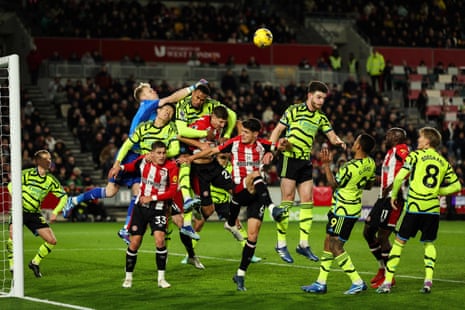 Aaron Ramsdale jumps to punch the ball through a crowd of players