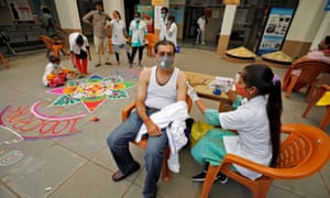 A healthcare worker gives a dose of the Covid-19 vaccine to a man inside a vaccination centre in Ahmedabad, India.