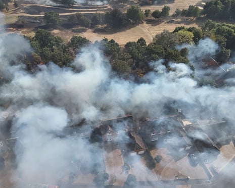 An aerial view of smoke from the grassfire engulfing homes and woodland