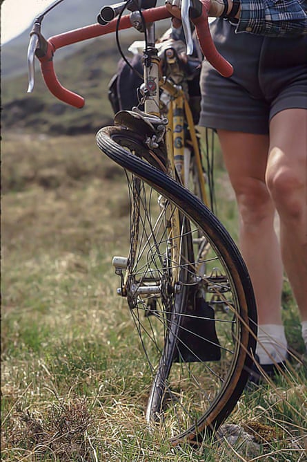 A cyclist shows examines his bent wheel. They were able to fix it and continue their journey