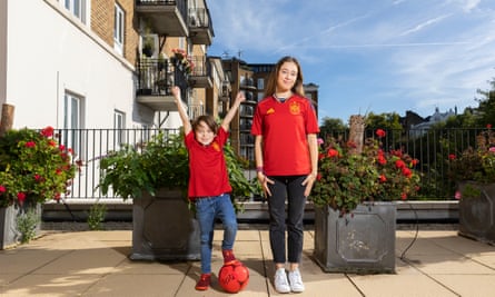Nico and Candela Lorenzo standing on a large balcony wearing red Spain shirts