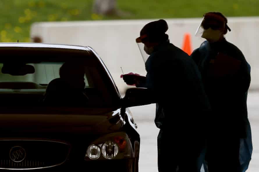 Healthcare worker test a resident at a drive-through Covid-19 testing site in Waterloo.