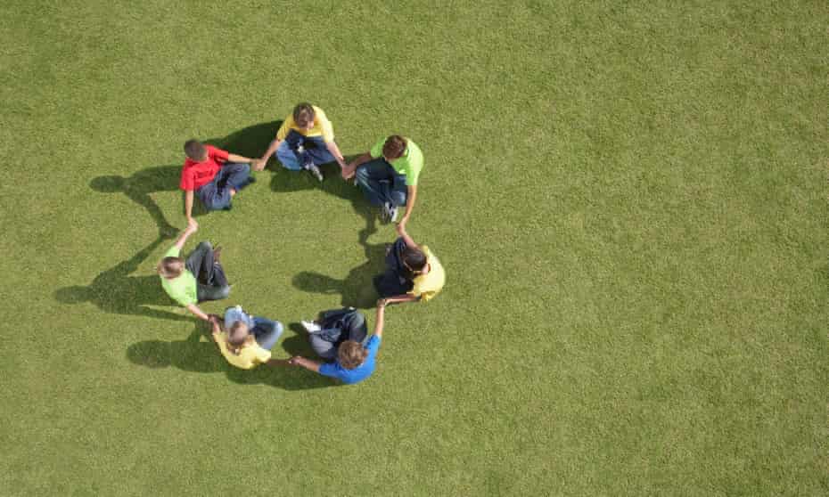 children sitting on grass in circle formation