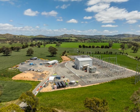Shed in green field in front of rolling hills