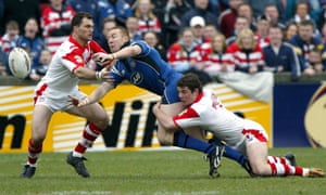 Paul Wellens (derecha) de St Helens y Jason Hooper abordan a Kris Radlinski de Wigan durante el empate 21-21 en la Super League en 2004.