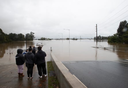Locals take in the flooded Windsor Bridge roadway.
