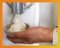 A hand holds a bowl catching soft serve ice cream from the Cuisinart Frost Fusion machine.