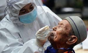 A healthcare worker takes a swab sample from an elderly man with mental illness to test for coronavirus at a social home in Jakarta, Indonesia.