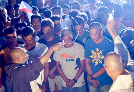 Filipino fishers are blessed by priests during a mass on Tuesday, on the eve of their voyage to Scarborough shoal