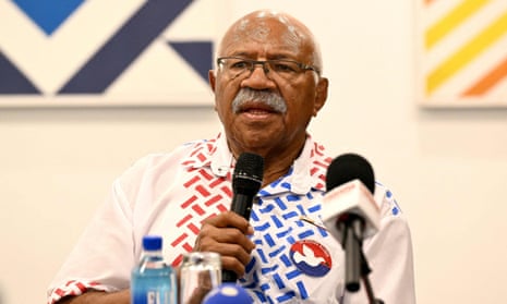 Sitiveni Rabuka sitting in a meeting and speaking into a microphone