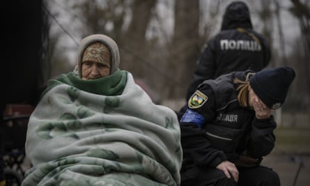 A Ukrainian police officer is overwhelmed by emotion after comforting people evacuated from Irpin on Saturday
