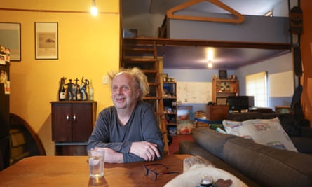 Tim Dakin sitting at the table in his off-grid home