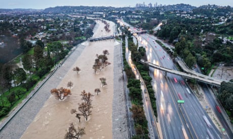 Cars drive past a river