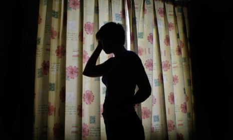 A silhouetted woman holds her head in her hands