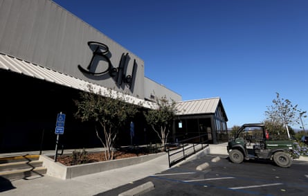 grey building with black logo in front of parking lot
