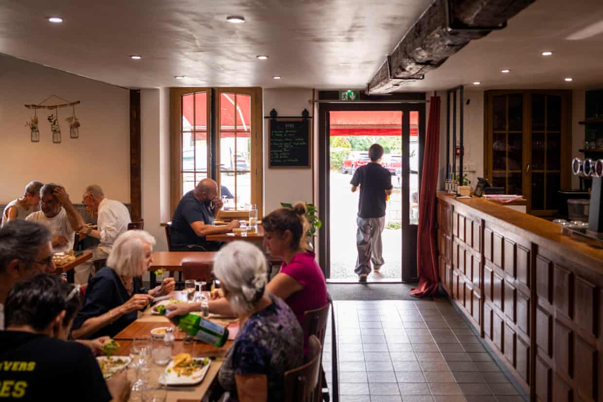 Customers eating at tables inside the Au Bon Accueil restaurant