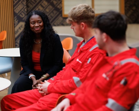 Miatta Fahnbulleh sitting with workers in red overalls