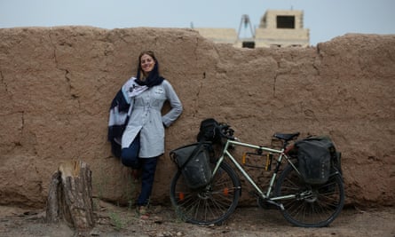 Rebecca Lowe standing by her bike, in the Middle East
