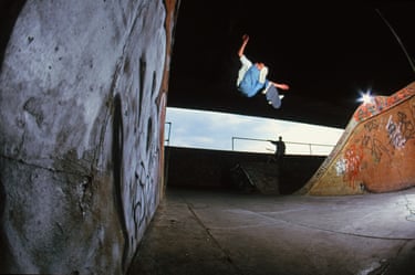 A person jumping high in the air on a stakeboard