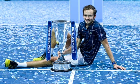 Daniil Medvedev sits down on court with the ATP Tour Finals Trophy