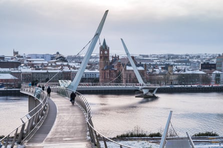 A footbridge over a wide river in a city