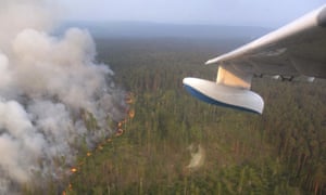 A jet prepares to pour water on to a forest fire in Krasnoyarsk, Russia.