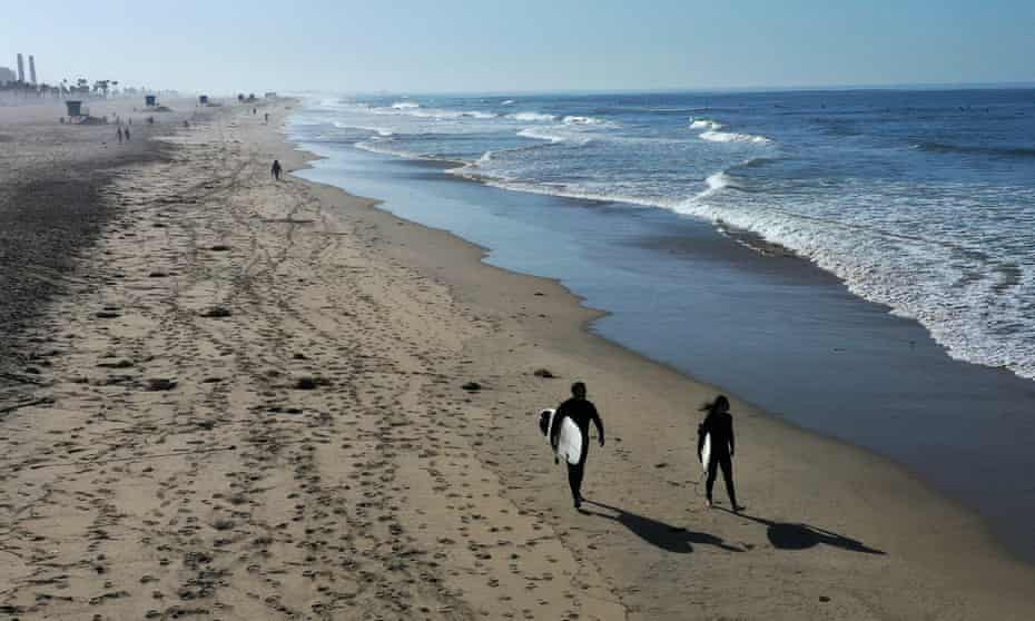 Surfers enjoy a cloudless morning at Huntington Beach, California.