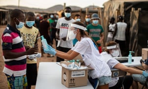 Workers lining up for hand sanitiser in El Nazareno shantytown