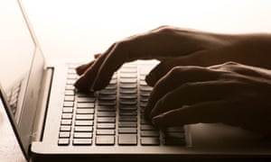 Hands on a laptop keyboard.