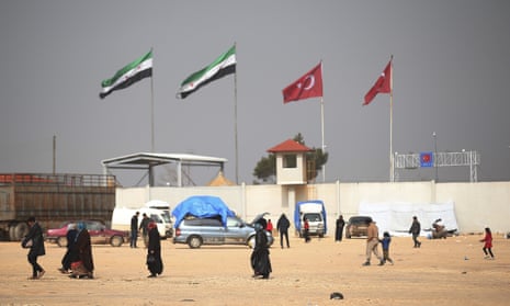 People on the Syrian side of a border crossing with Turkey in February