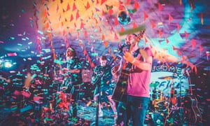 Band perform on stage amid tickertape at Camp Wildfire festival, Kent, UK.