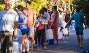 Residents queue to fill plastic water bottles and containers at a spring in Cape Town, South Africa.