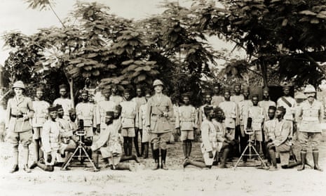 Three British officers pose with an artillery company of the Nigeria Regiment of the Royal West African Frontier Force, 1918. 
