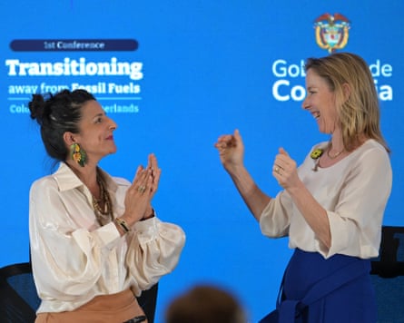 The 2 women are smiling and facing each other