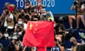A Chinese flag is unfurled on the podium of a swimming event at the 2020 Olympics in Tokyo