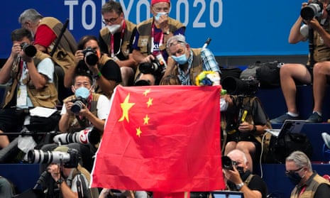 A Chinese flag is unfurled on the podium of a swimming event final at the Tokyo Olympics.