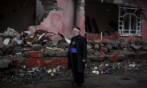 Pastor Saher Quraikos Hanna views a destroyed street near his home in Bartella.