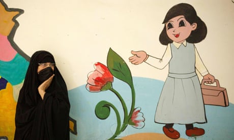 An Iraqi woman in Basra, brightly painted mural behind of a young girl off to school