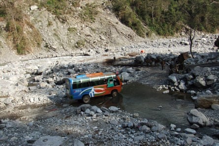 A minibus crosses a rocky ravine in the Himalaya region