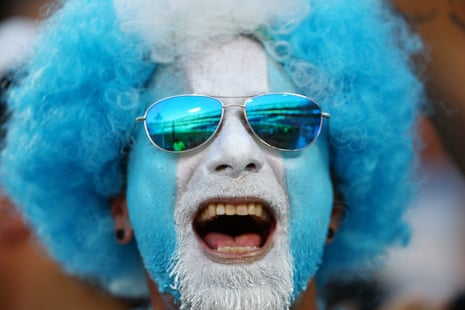An Argentina fan with his face painted blue and white