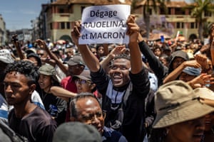 A protester holds a banner critical of Madagascar’s President Andry Rajoelina and France’s President Emmanuel Macron at a rally