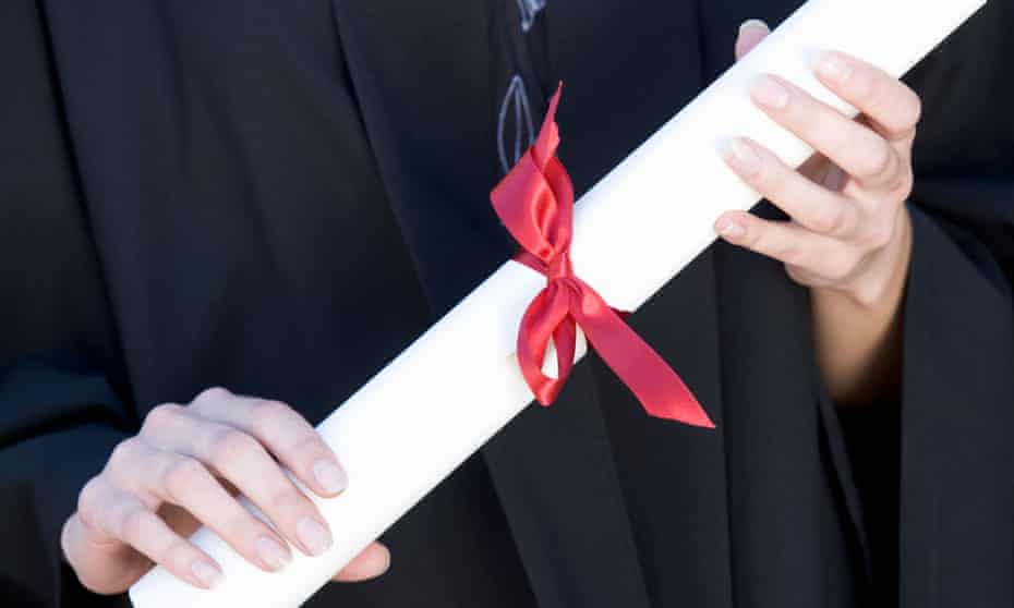A graduate holding a degree certificate scroll