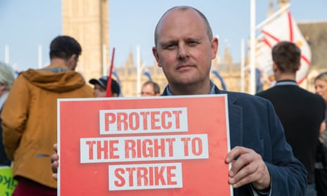 Paul Nowak holds up sign saying: 'Protect the right to strike,' during a demonstration in Parliament Square, London.