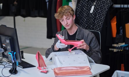 Vestiaire Collective authenticator Sam French inspects a pair of Amina Muaddi shoes