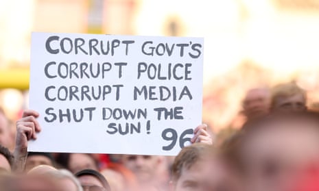 A Liverpool fan holding up a sign saying 'corrupt governments, corrupt police, corrupt median – shut down the Sun'