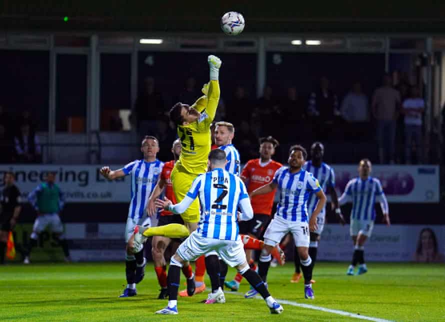 Huddersfield Town goalkeeper Lee Nicholls attempts to punch clear.