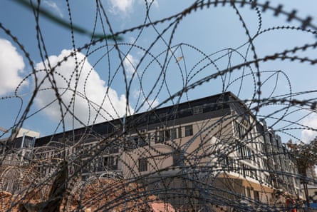 A large building behind barbed wire