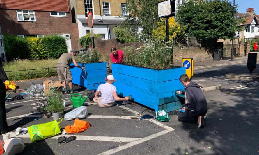 People repaint a planter that was covered in oil in Lambeth