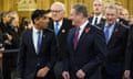 Rishi Sunak and Keir Starmer look at each other with grins on their faces as they lead a procession of politicians at Westminster