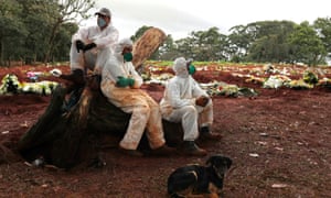 Gravediggers wearing protective suits rest between burials amid the coronavirus outbreak at Vila Formosa cemetery, in Sao Paulo, Brazil, 27 June 2020.